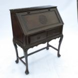 An oriental design rosewood bureau, having carved decoration to the fall flap over two short