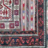 An Eastern style rug, decorated with repeating symbols to a red and cream ground, 71ins x 46ins,