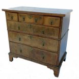 An 18th century walnut chest, of three short drawers over two long drawers, below a replacement top,