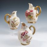 A graduated set of three Royal Worcester blush ivory flat back jugs, decorated with flowers, shape