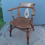 A possible elm wood captain's chair, raised on turned legs united by a stretcher, stamped G.B. 150