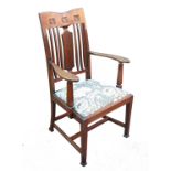 A 19th century Arts & Crafts oak armchair, having a shaped back splat and carved top rail with