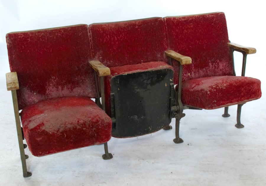 Six sections each of three cinema seats, with folding seat, red upholstery, wooden arms and  metal