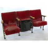 Six sections each of three cinema seats, with folding seat, red upholstery, wooden arms and  metal