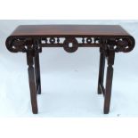 An Oriental hardwood altar table, of rectangular form with curved ends, having a carved frieze and