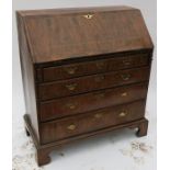 A Georgian walnut bureau, the sloping fall flap opening to reveal pigeonholes and drawers, over four