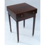 A late Georgian mahogany free standing lamp table, having an overhanging top and single drawer,