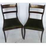 A set of six mahogany and cut brass inlaid Regency dining chairs, with bar back, raised on sabre