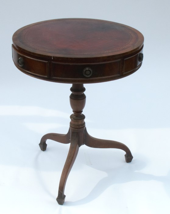 A mahogany drum table, fitted with three short drawers and three dummy drawers, raised on a turned