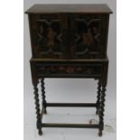 A Chinoiserie style cabinet on a stand, the two doors opening to reveal a shelf, the base fitted