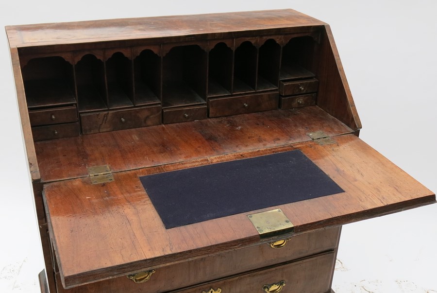 A Georgian walnut bureau, the sloping fall flap opening to reveal pigeonholes and drawers, over four - Image 2 of 3