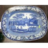 An 19th century English blue and white meat plate, decorated with figures boating in a landscape