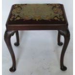 A mahogany dressing table stool, with tapestry seat, raised on scroll legs with carved decoration