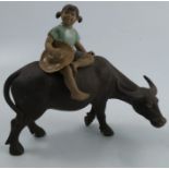 An Oriental model, of a girl sitting on a buffalo, character mark to underside, height 7insCondition