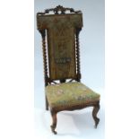 A Victorian prie dieu chair, with floral tapestry seat and T shaped back having ecclesiastical