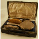 A cased hallmarked silver dressing table set, comprising a hand mirror, a comb and two brushes,