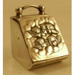 A hallmarked silver stamp box, in the shape of a coal scuttle, with angel's faces to the lid,