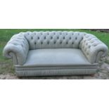 A two seater Chesterfield settee, upholstered in pale green leather