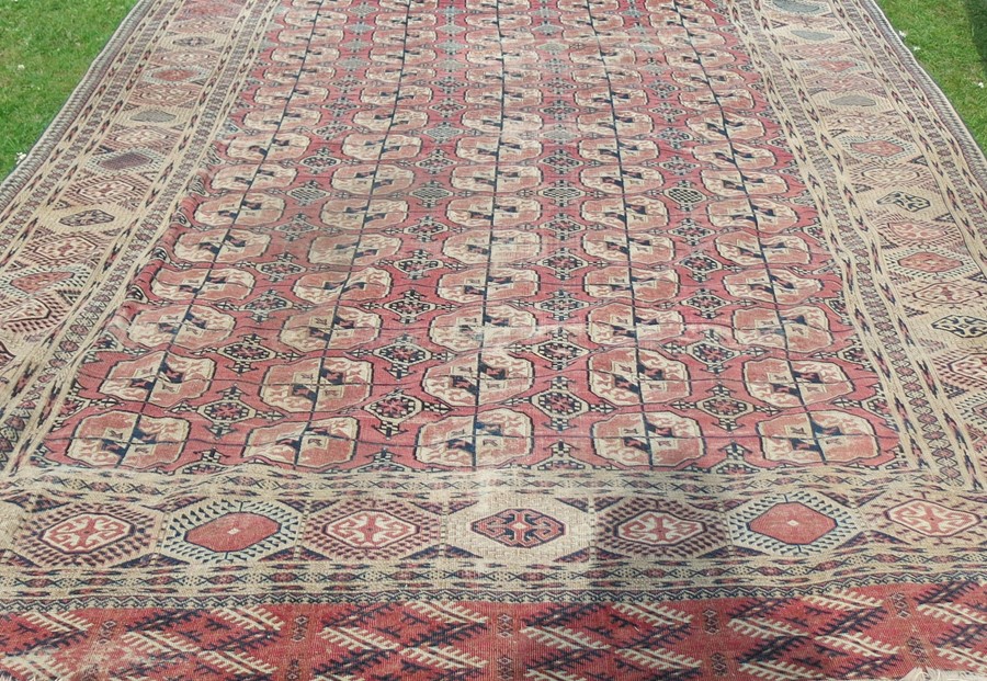 An Eastern style rug, decorated with repeating motifs to the field and hooked gulls to the