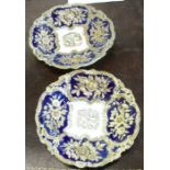 A pair of continental dishes, having gilt floral relief panels to a blue ground, with cross sword