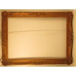 A gilt wood and composition picture frame, with pierced scrolls to the sides and corners,