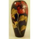 A Moorcroft Pottery vase, decorated in the Hibiscus pattern to a dark blue ground, af, height 12.