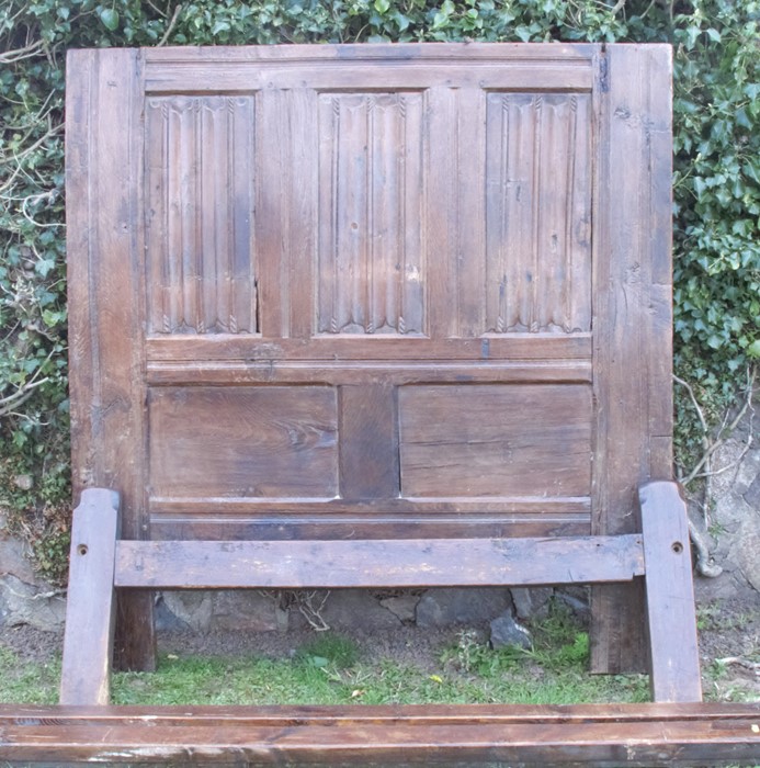 An antique oak bed frame, the back board having HC monogramme, with three fielded carved panels over