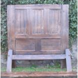 An antique oak bed frame, the back board having HC monogramme, with three fielded carved panels over