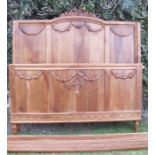 A walnut bed frame, having carved floral swag decoration, width 60ins, maximum height 53ins,