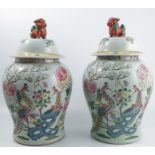 A pair of 20th century Chinese covered baluster vases, decorated with polychrome colours with