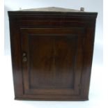 An antique oak corner cupboard, the door opening to reveal fitted shelves, width 32ins, height