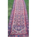 An Eastern runner, the field decorated with flower heads and hooked motifs, 150ins x 36ins