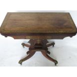 A 19th century rosewood and cut brass fold over games table, raised on an inlaid column to a