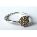 A seven stone diamond cluster ring, the white mount stamped '18ct Pt', the old cut diamonds