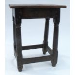 An antique oak joint stool, raised on four turned legs united by a stretcher, top 17.5ins x 11.5ins,