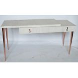 A 1970's Cantori Italy white wood dressing table, having rose gold coloured drop handles, raised