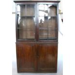 A Regency mahogany glazed book case, in two parts, top section having a pair of glazed doors, the