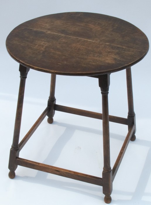 A circular oak occasional table, raised on four turned legs, united by a stretch, diameter 21ins,