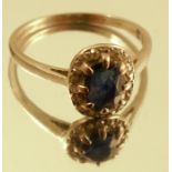 A sapphire and diamond cluster ring, the white mount unmarked, the oval cut stone enclosed by