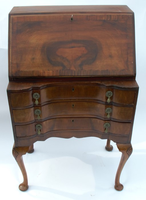 A Queen Anne style walnut bureau, the fall flap opening to reveal a fitted interior, over three long