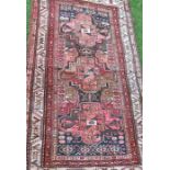 An Eastern style rug, decorated with three large motifs to the field, 78ins x 43ins