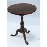 A 19th century mahogany tripod table, raised on a turned baluster column, terminating in outswept