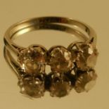 A three stone diamond ring, the white mount stamped '18ct Pt', the two outer old cut brilliants of