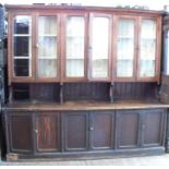 A Victorian stained pine dresser, the upper section having three pairs of glazed doors, the base