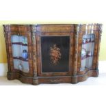 A Victorian walnut serpentine fronted credenza, the central cupboard inlaid with flowers, flanked by