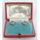 A pair of moonstone and diamond earrings, the round cabochons, of approximately 8.5mm diameter, with