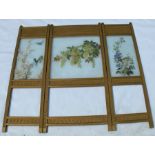 An Edwardian three panel folding screen, having three painted opaque glass panels decorated with