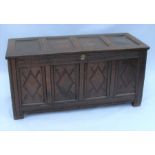 An Antique oak coffer, with four panelled rising lid, over a four panelled front with diamond