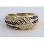 An 18 carat gold diamond and calibre sapphire dress ring, channel set with twenty seven brilliant