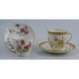 A Royal Worcester cup and saucer, decorated with flowers, together with another cup and saucer,